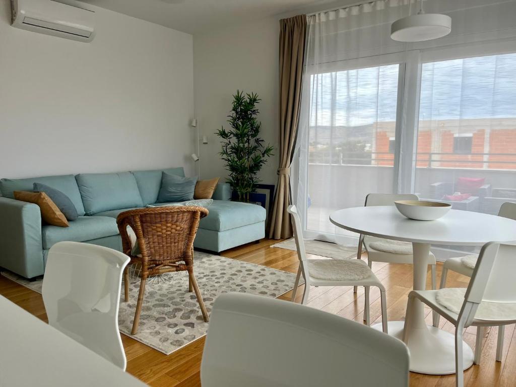 a living room with a couch and a table and chairs at EllaSea - Beachside in Zaboric