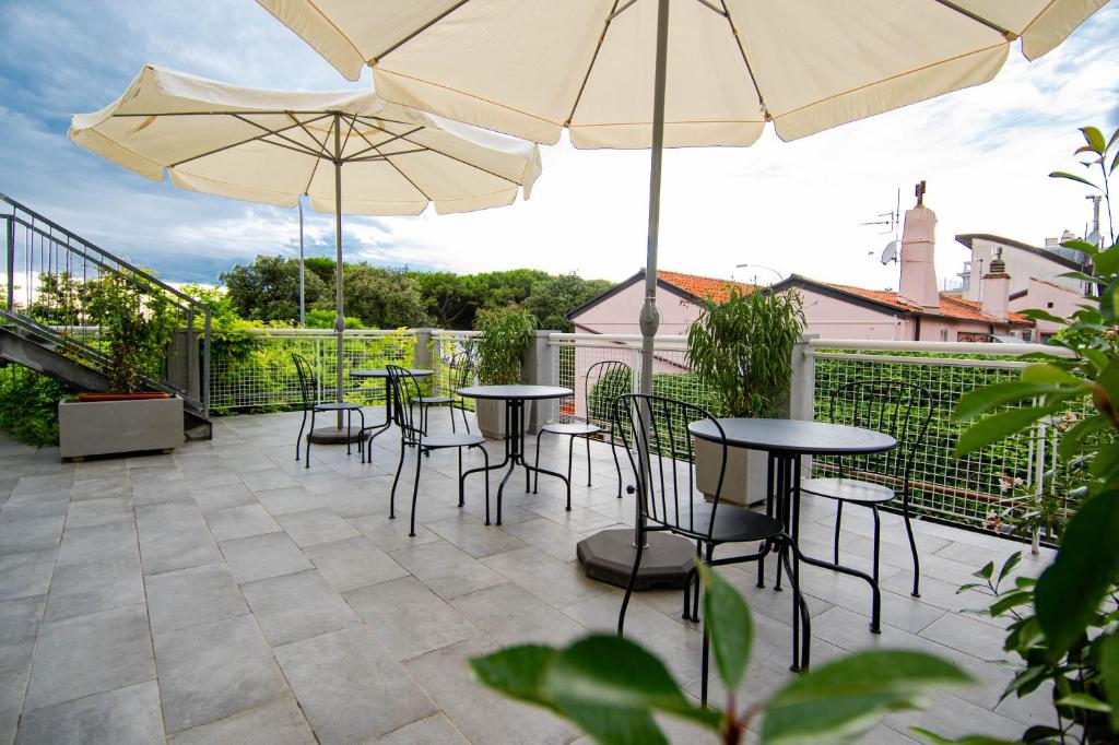 a patio with tables and chairs and umbrellas at Hotel Tritone in Trieste