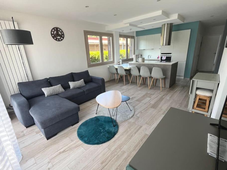 a living room with a blue couch and a table at Le Balnéo in Thonon-les-Bains
