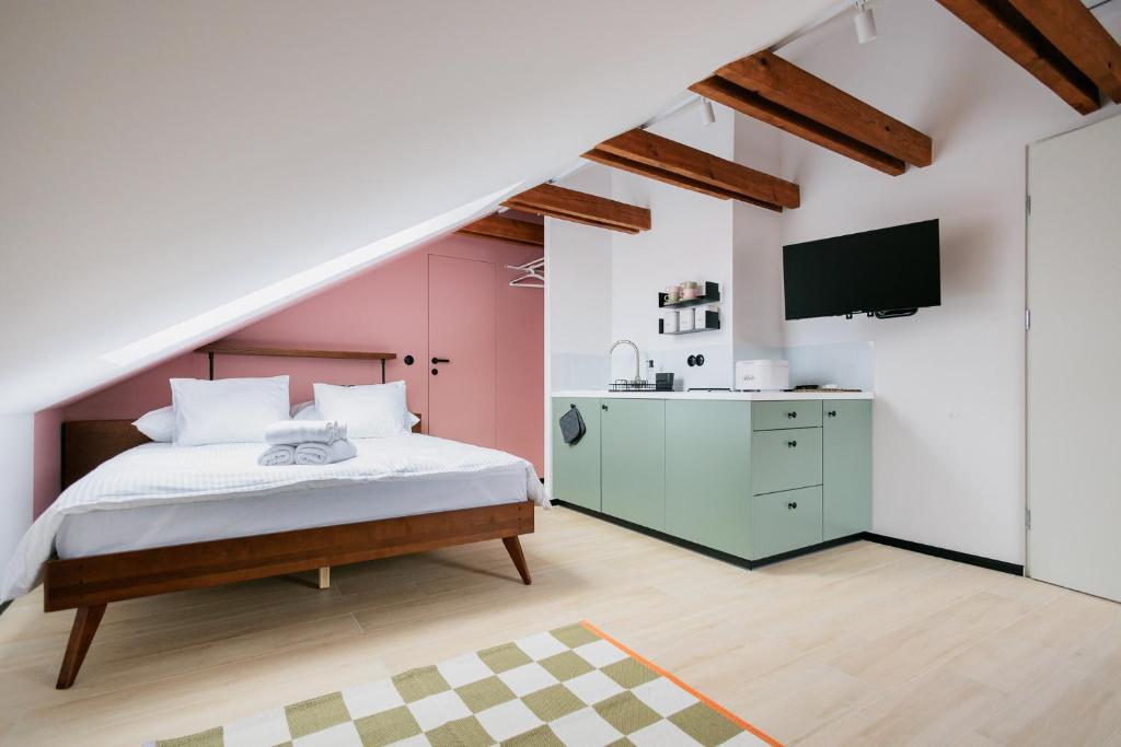 Un dormitorio con una cama y un televisor en la pared. en Apartamenty Mostowa - klimatyczny nocleg z widokiem w centrum Iłży, en Iłża