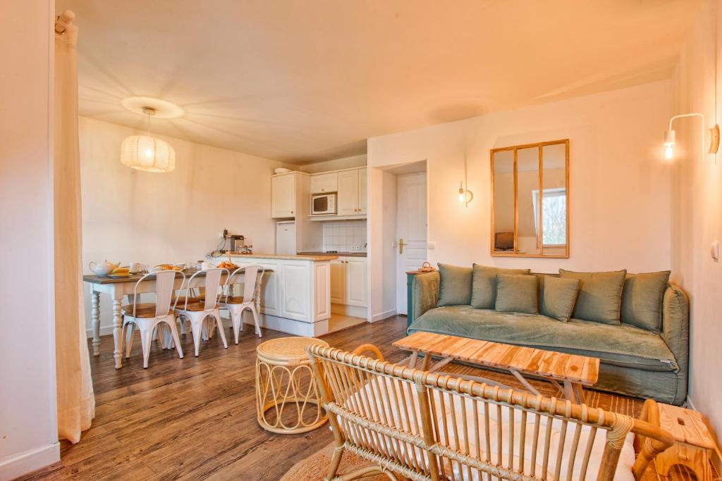 un salon et une cuisine avec un canapé et une table dans l'établissement Petit Golf résidence privée piscine chauffée, à Deauville