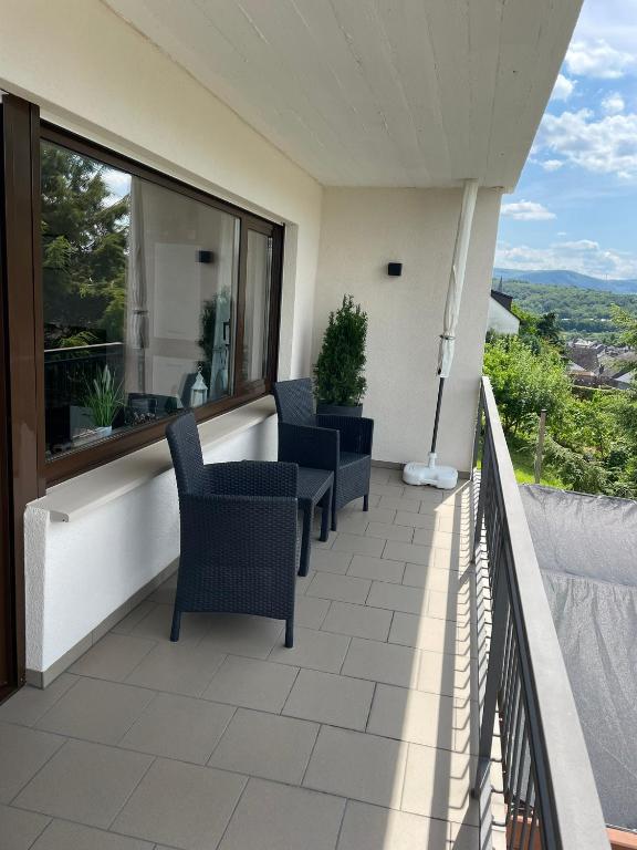 a balcony with chairs and a view at Ferienwohnung im Kirchberg in Lieser