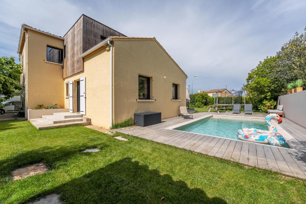 une maison avec une piscine dans une cour dans l'établissement Piscine, clim, terrain de pétanque et jeux enfants, à Montpellier