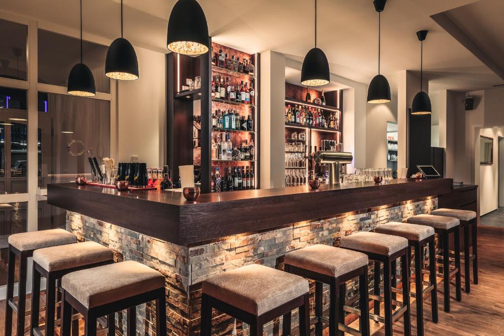 a bar with a row of bar stools at Bahnlounge 1907 in Neuenstadt am Kocher