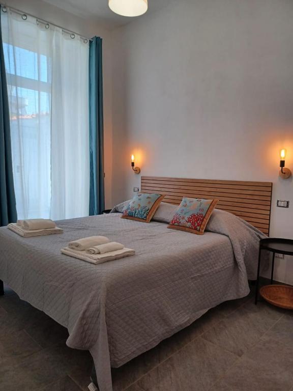 a bedroom with a large bed with two towels on it at Holiday Homes Villetta Blu in Nettuno