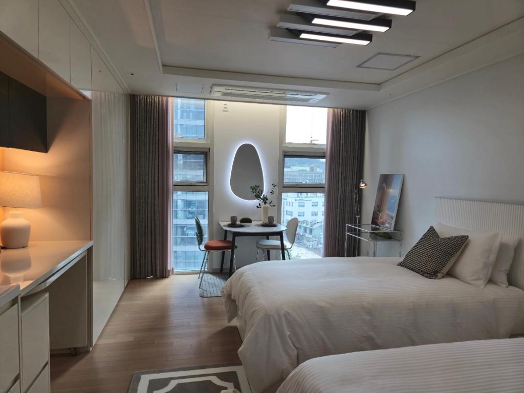 une chambre d'hôtel avec deux lits et une table dans l'établissement Sunshine house, à Séoul