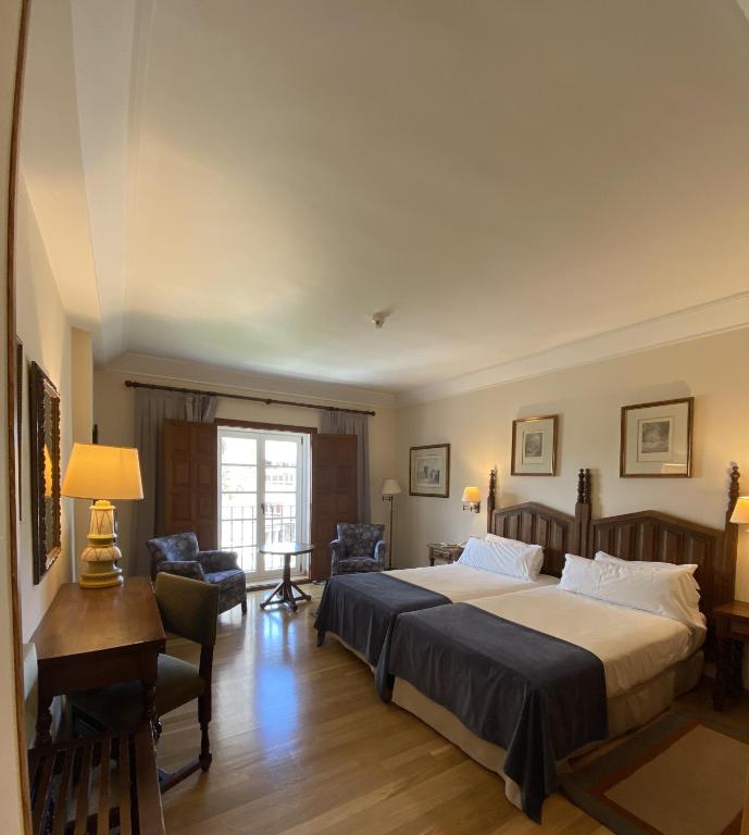 A bed or beds in a room at Parador de Vilalba
