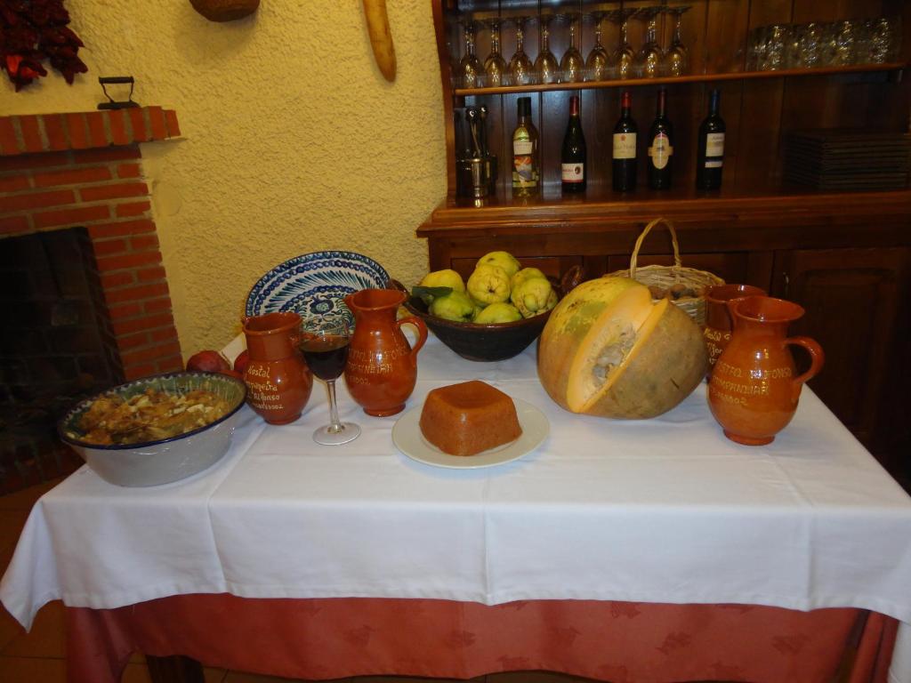 a table with bowls of fruit and vases on it at Hostal Pampaneira in Pampaneira