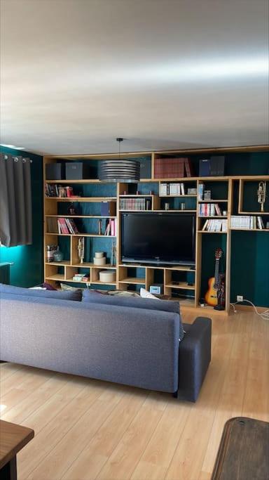 un salon avec un canapé et une télévision dans l'établissement La Canopée - Famille - 4 pers, au Havre