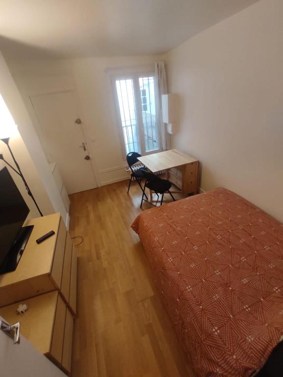 une chambre avec un lit, un bureau et une table dans l'établissement Rahim, à Paris