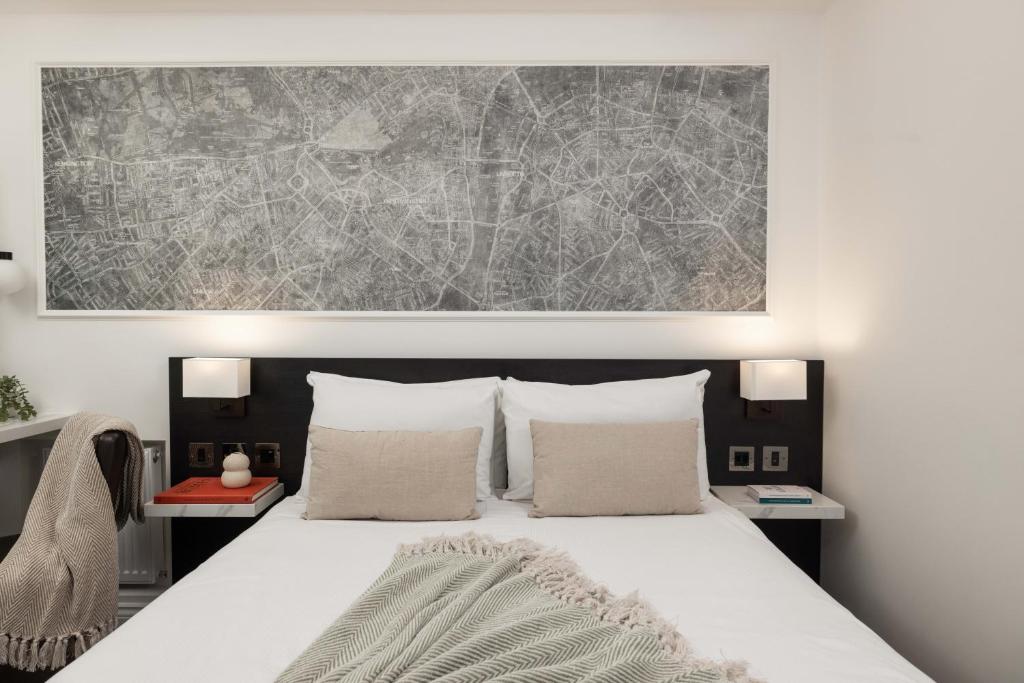 a bedroom with a large bed with two pillows at St Giles London – A St Giles Hotel in London