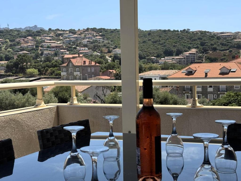 - une bouteille de vin assise sur une table avec des verres à vin dans l'établissement Joli T2 idéalement situé, à Propriano
