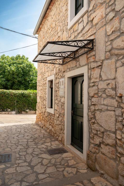a stone building with a green door on it at Villa Maria in Pašman