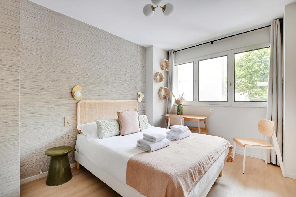 Un dormitorio con una cama con sábanas blancas y una ventana. en Green Suites Résidence Meudon Velizy, en Meudon
