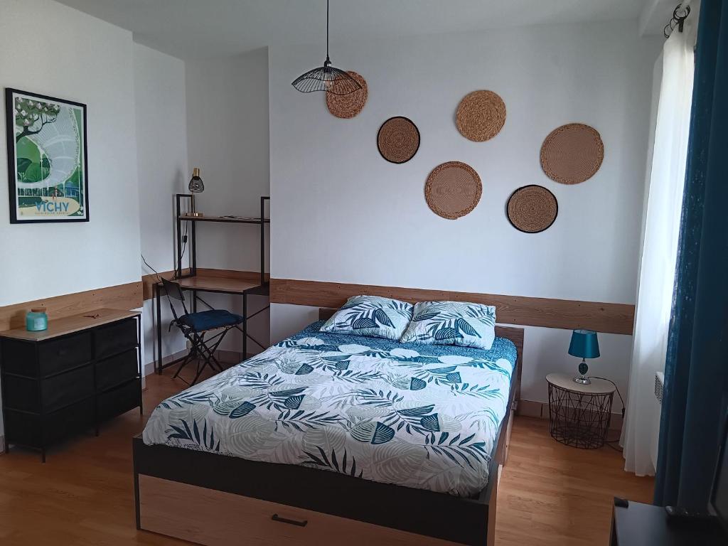 une chambre avec un lit et deux miroirs au mur dans l'établissement joli studio idéalement situé, à Vichy