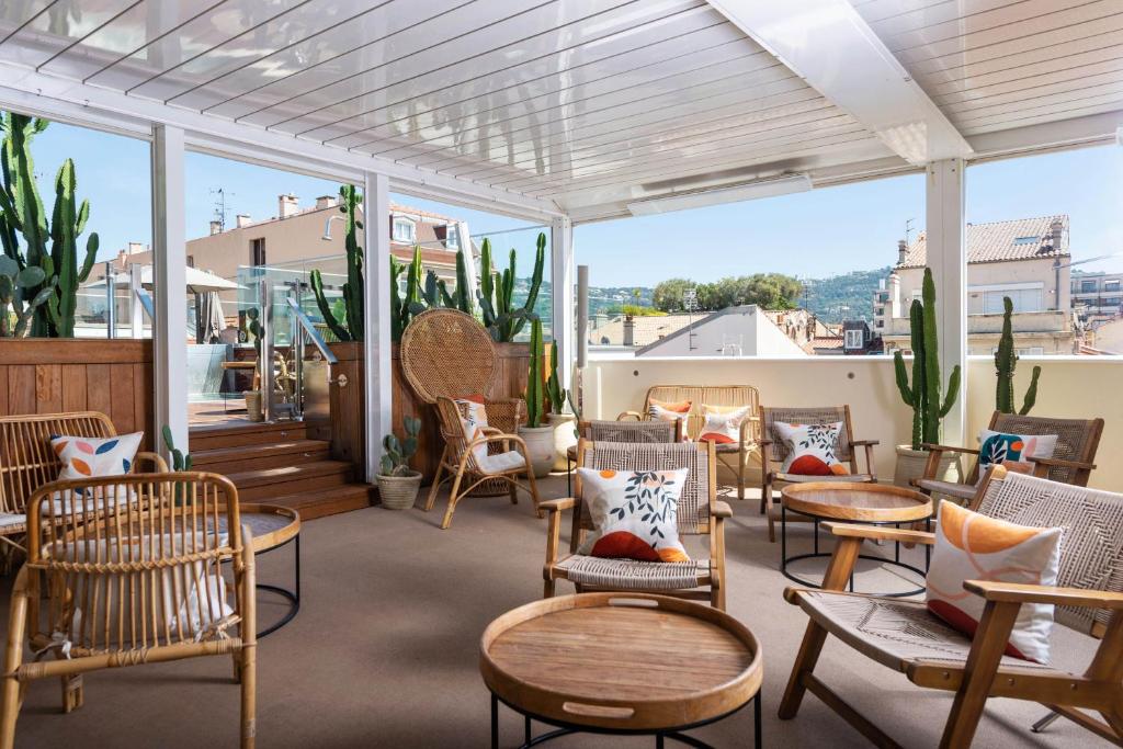 a patio with chairs and tables and windows at Five Seas by Inwood Hotels in Cannes