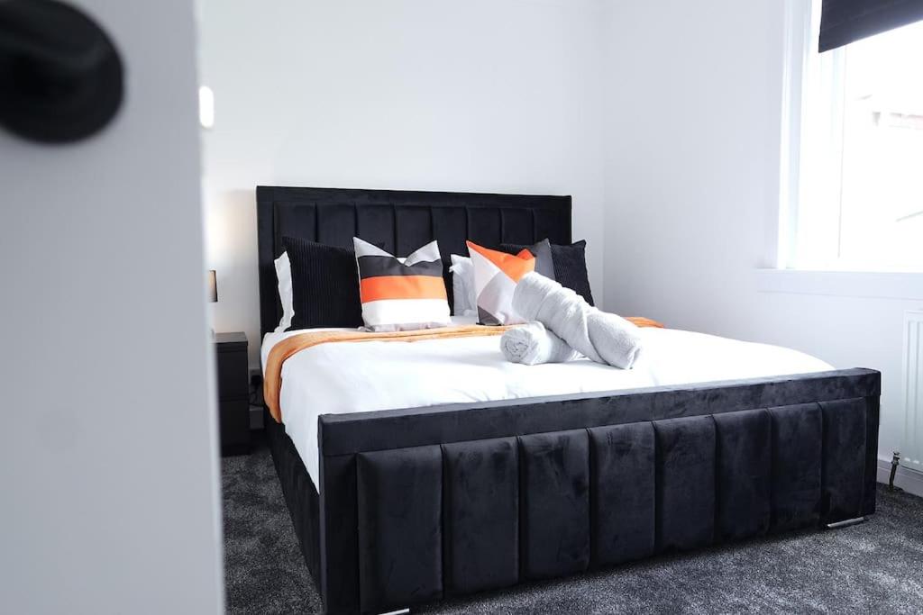 a bedroom with a large black bed with pillows at Modern 3 Bedroom Apartment in Millerhill