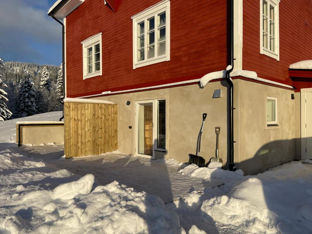 ein Haus mit rotem Dach im Schnee in der Unterkunft Solbergshyllan 2 in Åre