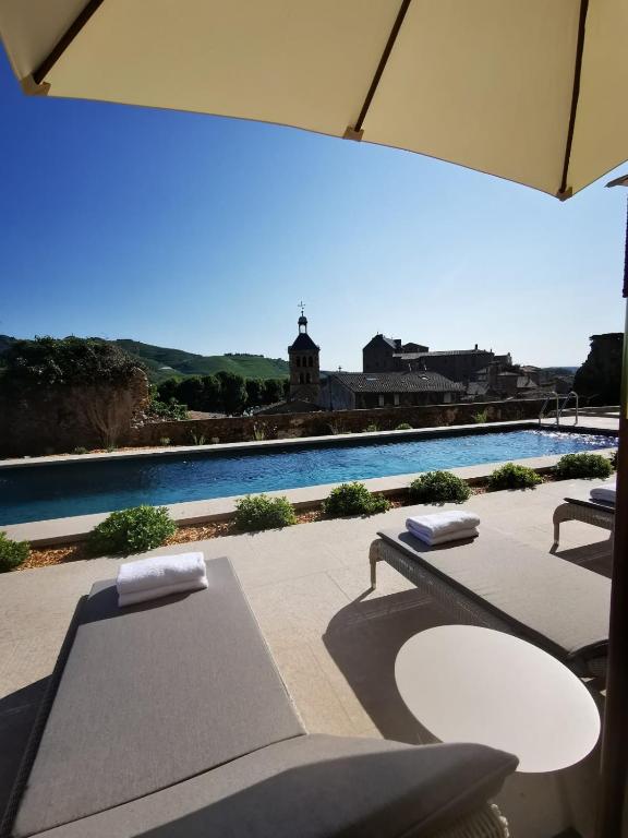 un patio avec une table et des chaises et une piscine dans l'établissement Hôtel de la Villeon, à Tournon-sur-Rhône