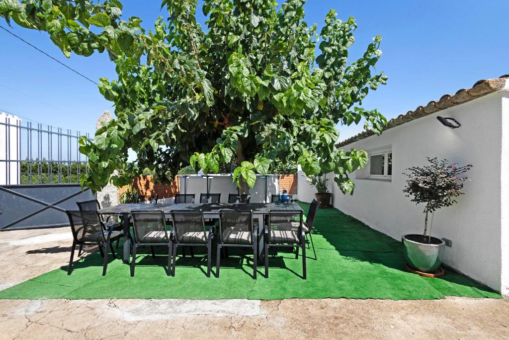 a table and chairs sitting under a tree at Cal Peret Miquelet in San Martín Sarroca
