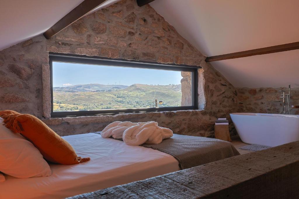 a bedroom with a bed with a tub and a window at Retiros do Vale in Vila Real