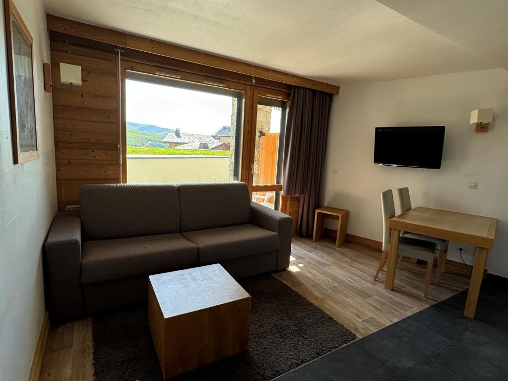 un salon avec un canapé et une table dans l'établissement Studio cabine avec balcon, piscine, spa, animaux admis, accès direct pistes - Belle Plagne - FR-1-181-2825, à La Plagne Tarentaise