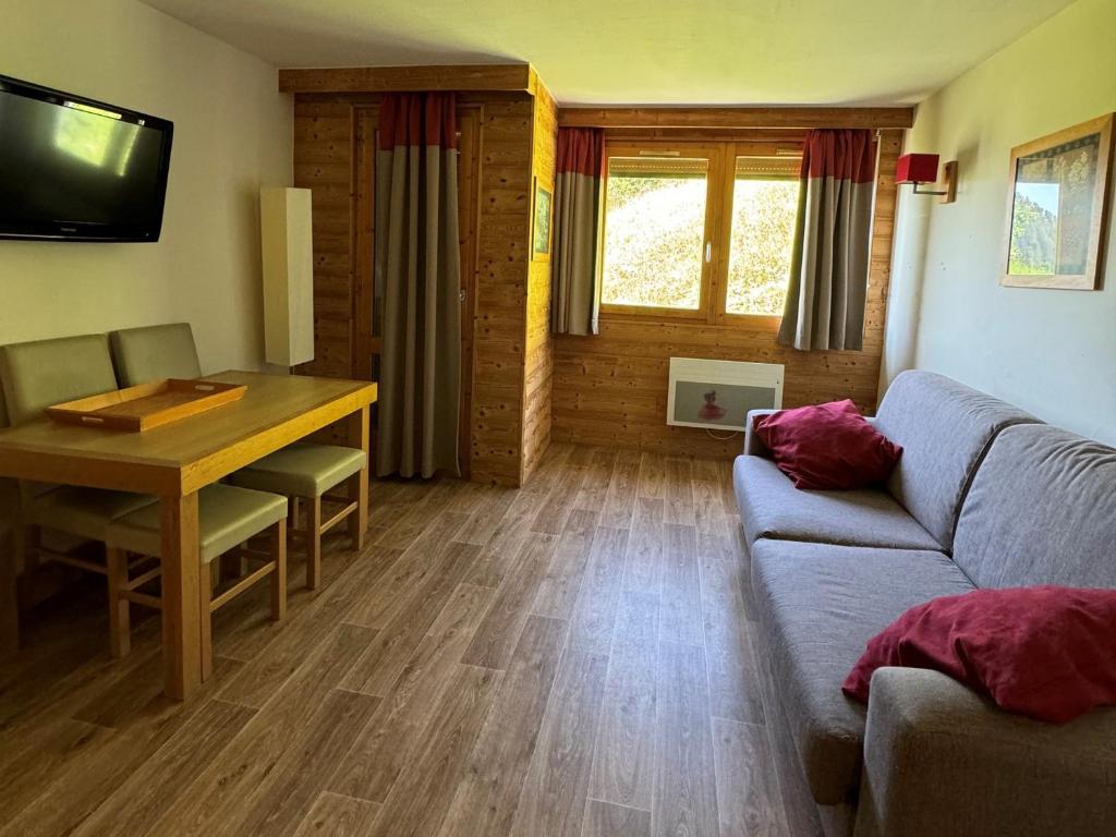 un salon avec un canapé et une table dans l'établissement Studio ski aux pieds avec piscine chauffée, WiFi et animaux admis - FR-1-181-2822, à La Plagne Tarentaise