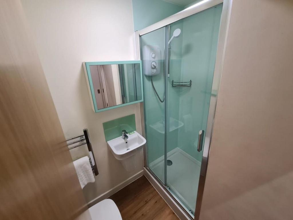 a bathroom with a glass shower and a sink at Harford House studios 22 - Hopewell in Bristol