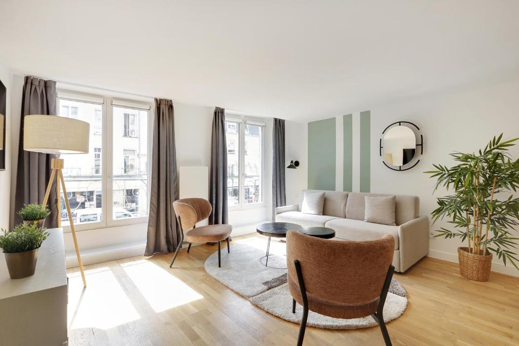 un salon avec un canapé et des chaises dans l'établissement Pick A Flat's Apartement in Saint-Martin - Rue du faubourg Saint-Martin, à Paris