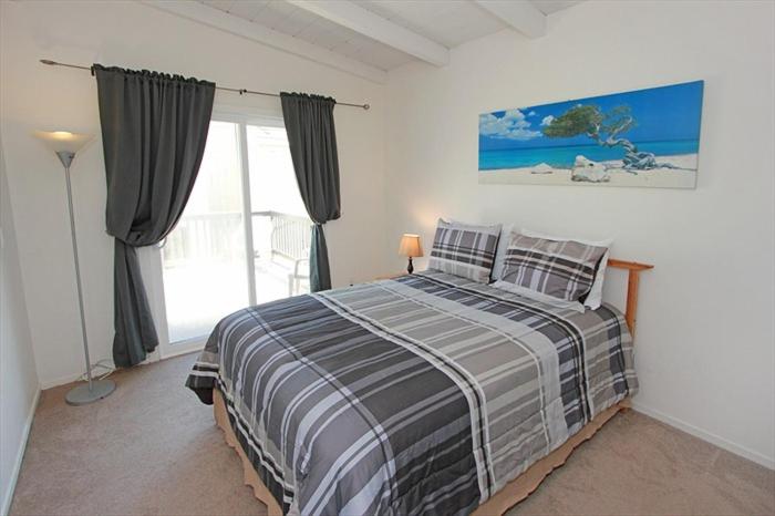 a bedroom with a bed and a large window at 124 Thirty Fourth Street B in Newport Beach