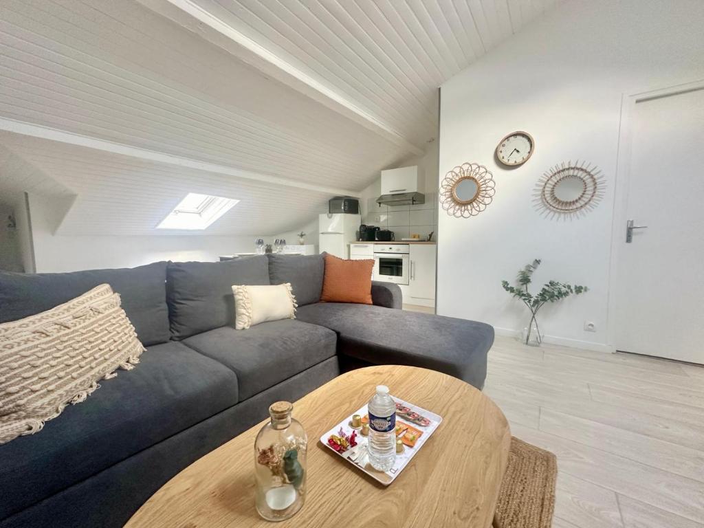 un salon avec un canapé bleu et une table dans l'établissement Les Bancs, central et calme, à Limoges