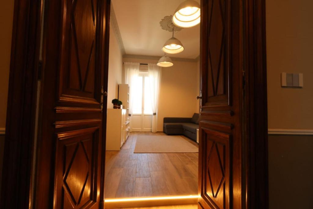 クーネオにあるBarolo Apartmentのリビングルーム(ソファ付)へのオープンドア
