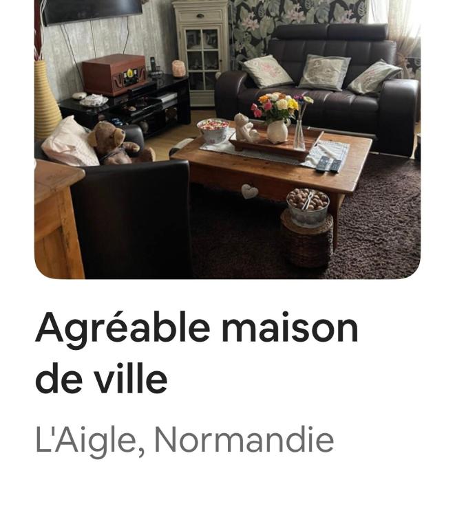 un salon avec un canapé et une table basse dans l'établissement Agréable maison de ville, à LʼAigle