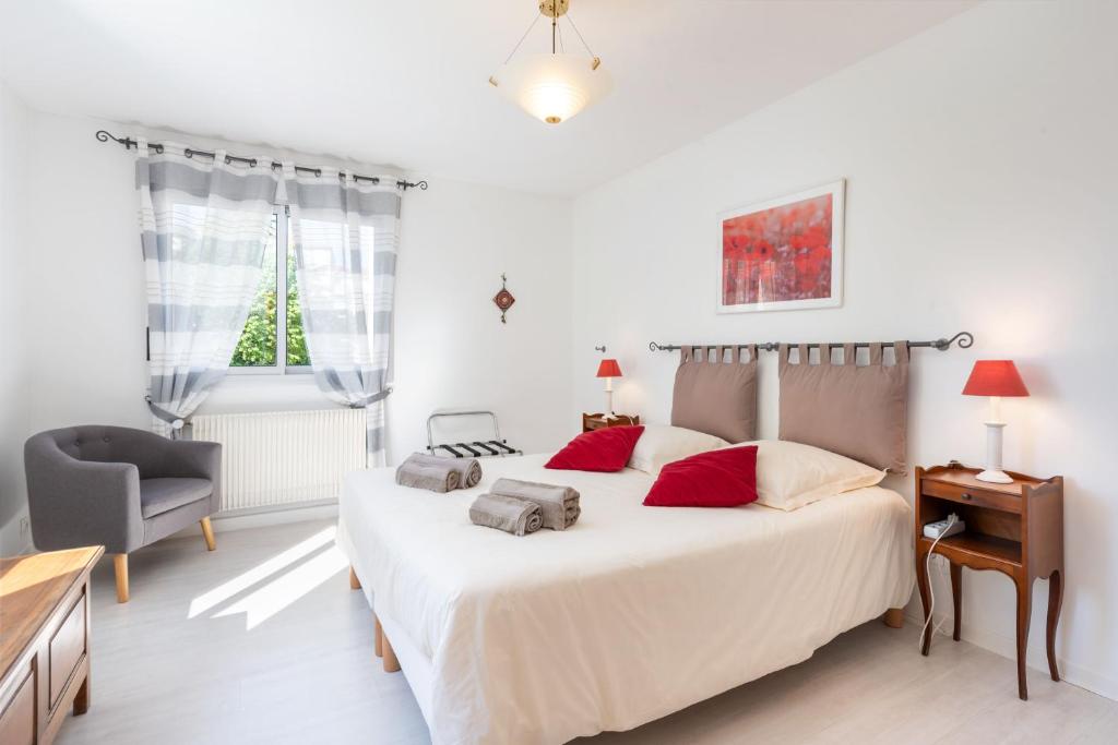 une chambre avec un grand lit blanc avec des oreillers rouges dans l'établissement L'Azalée - 106m2 quartier Monplaisir Lyon 8, à Lyon