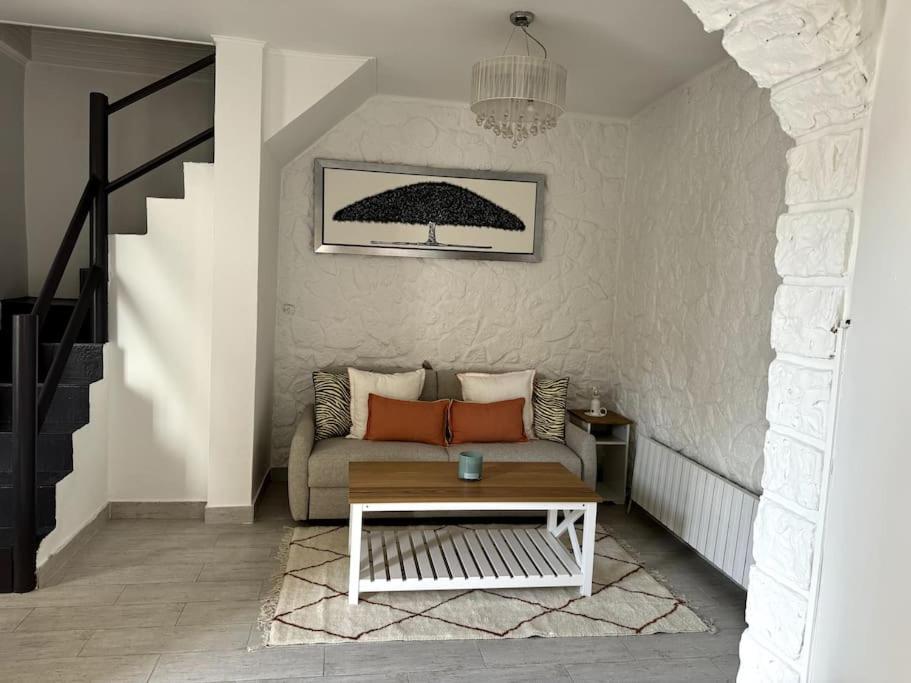 a living room with a couch and a table at Maison proche stade de France in Aubervilliers