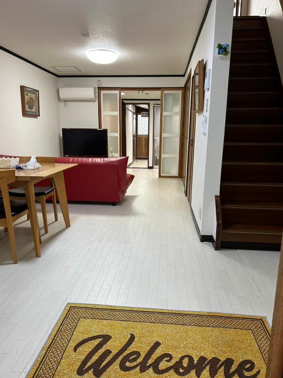 a living room with a welcome mat on the floor at 金の森民泊 in Osaka