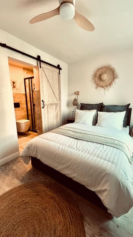 a bedroom with a large bed with a ceiling fan at Morze To Tu in Mielno