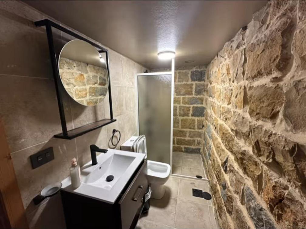 Un baño con lavabo y pared de piedra. en Bayt Al Habib, 