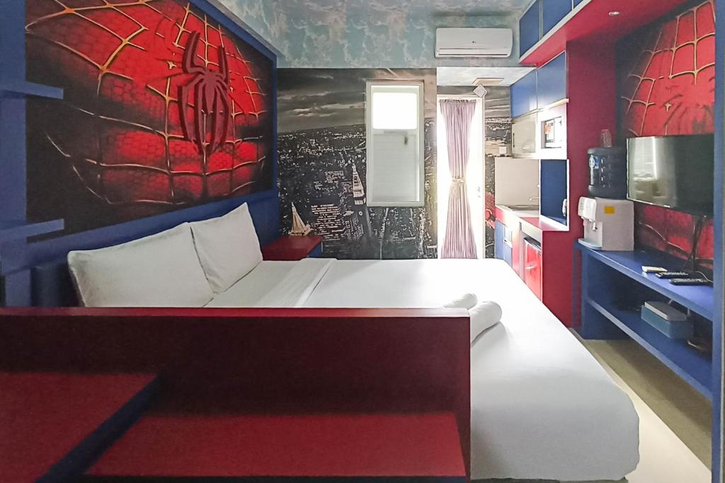 um quarto com uma cama com uma pintura do homem-aranha na parede em Good Deal Studio Apartment at Student Castle Yogyakarta By Travelio em Seturan