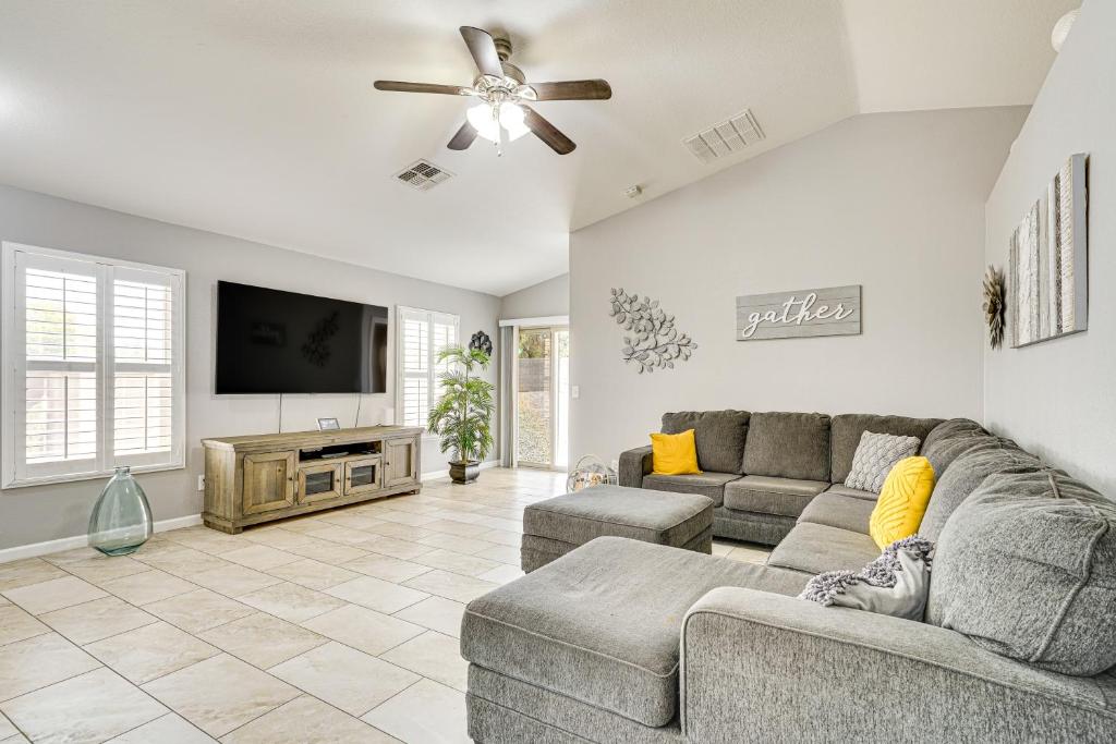 a living room with a couch and a flat screen tv at Tucson Home with Patio, Grill and Mountain Views! in Tucson
