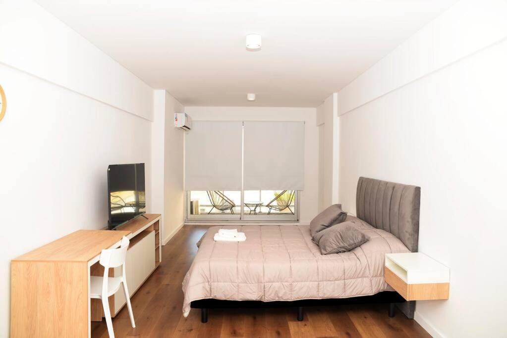 ein kleines Schlafzimmer mit einem Bett, einem Schreibtisch und einem Schreibtisch in der Unterkunft Belgrano amplio luminoso, cochera, WiFi, cerca River y Subte, 309 in Buenos Aires
