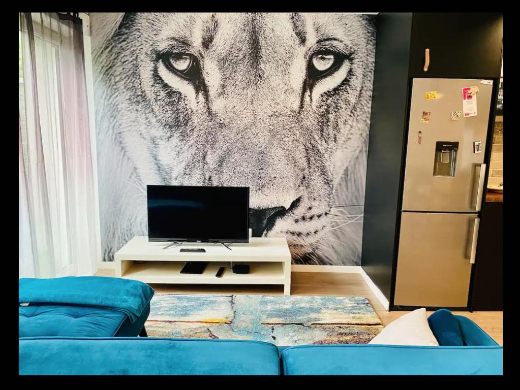 un salon avec une photo d'un lion dans l'établissement Cosy Appart, à Stains