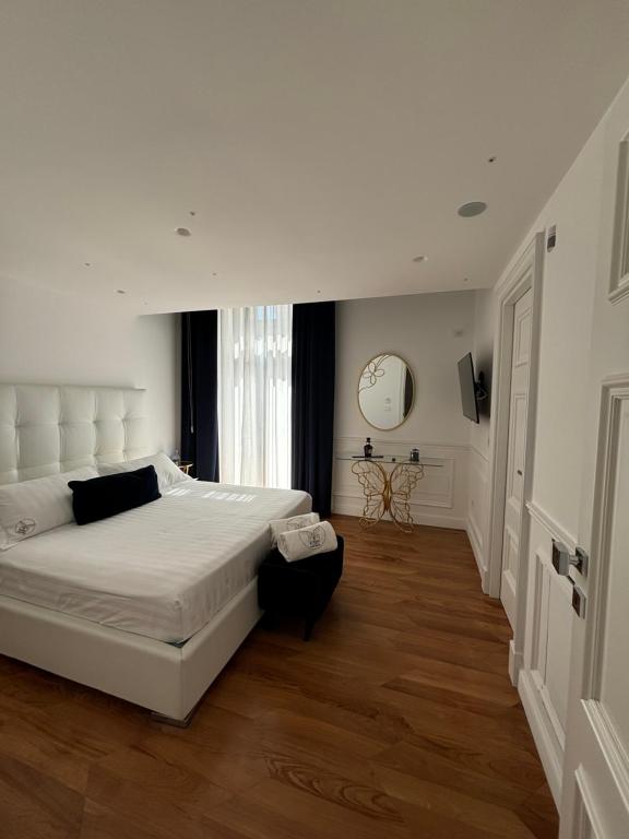 1 dormitorio con 1 cama grande y reloj en la pared en Stabia Junior Suite, en Castellammare di Stabia