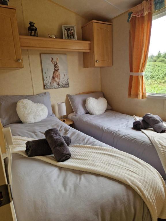 two beds in a room with towels on them at Lochview Retreat Caravan in Balminnoch
