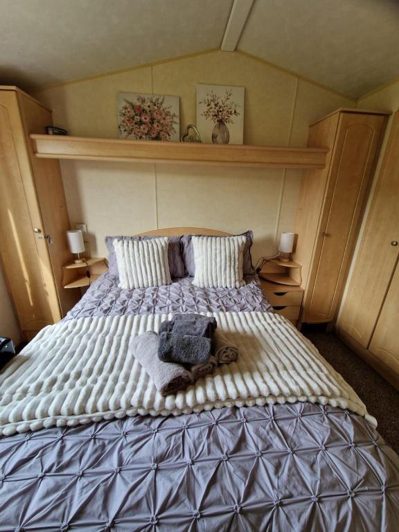 a bedroom with a large bed with towels on it at Lochview Retreat Caravan in Balminnoch