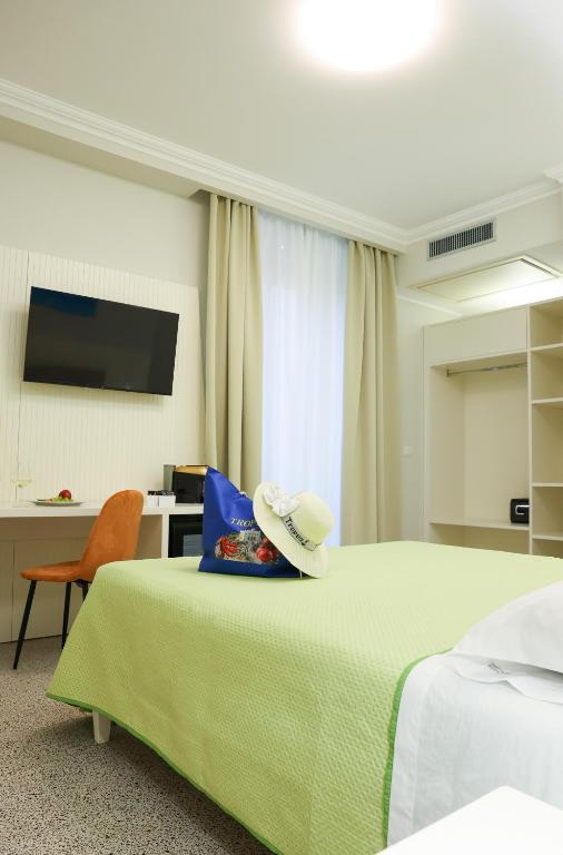 una camera da letto con un letto verde con un cappello sopra di Nazzarì B&B Tropea a Tropea