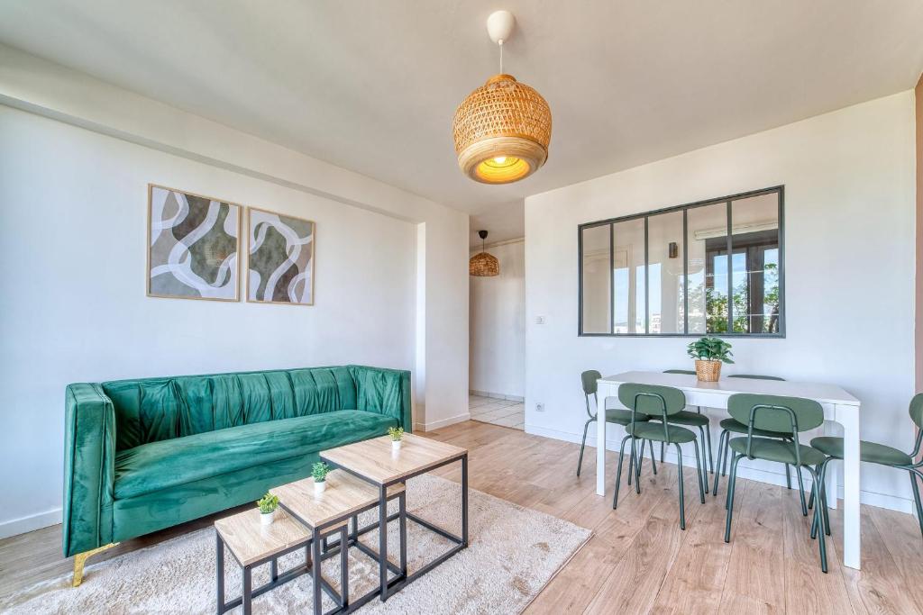 un salon avec un canapé vert et une table dans l'établissement Le Grand Voyageur - 3 chambres - Parking privé - Métro, à Vénissieux