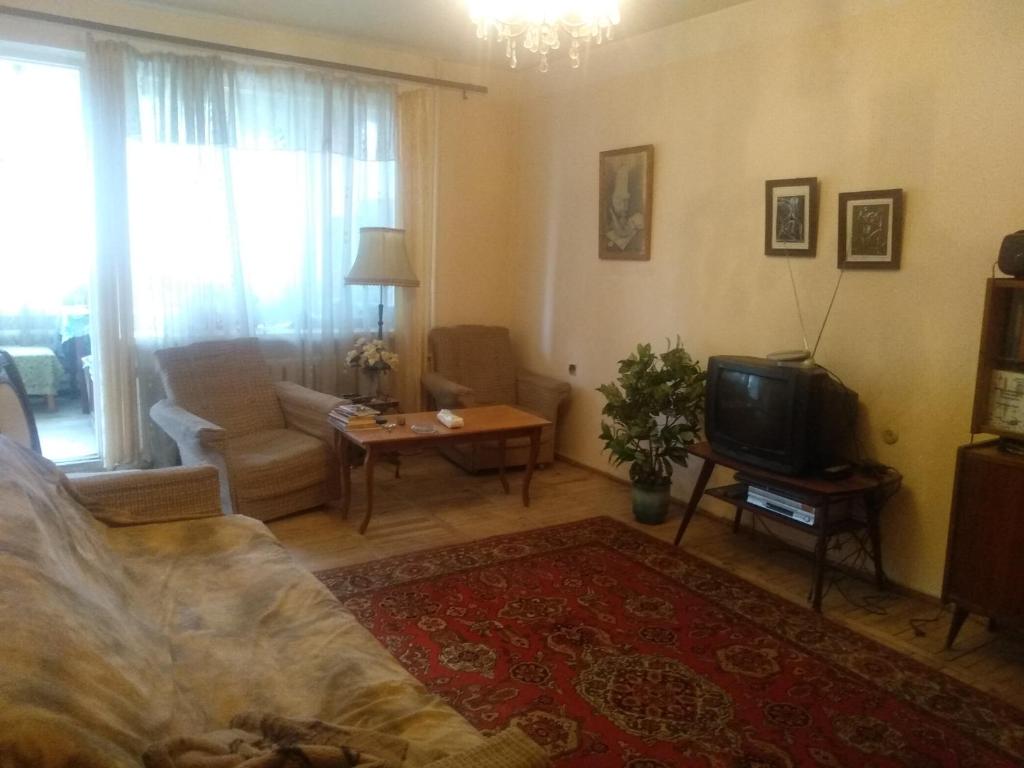 a living room with a couch and a tv at Комната в ретро стиле в трехкомнатной квартире с отдельным входом in Yerevan