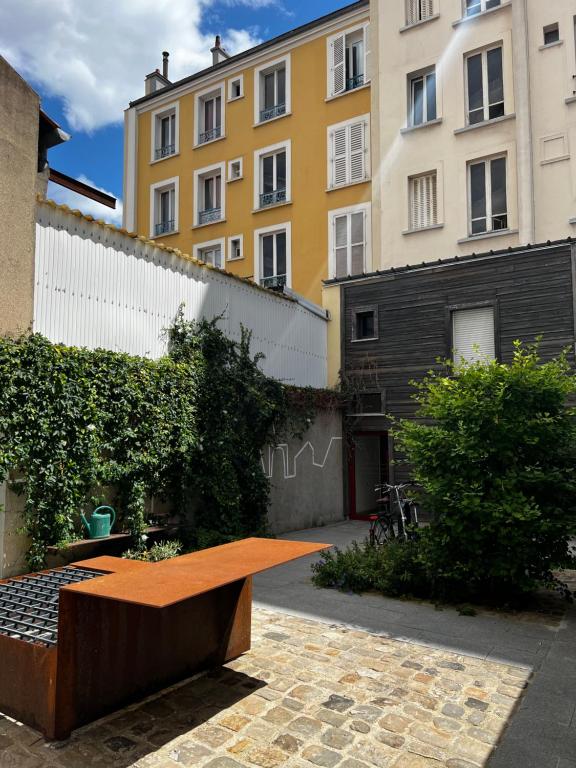 un banc dans une cour devant un immeuble dans l'établissement Charmant studio d'artistes - Paris - Parc des princes - Roland Garros - Trocadero, à Boulogne-Billancourt