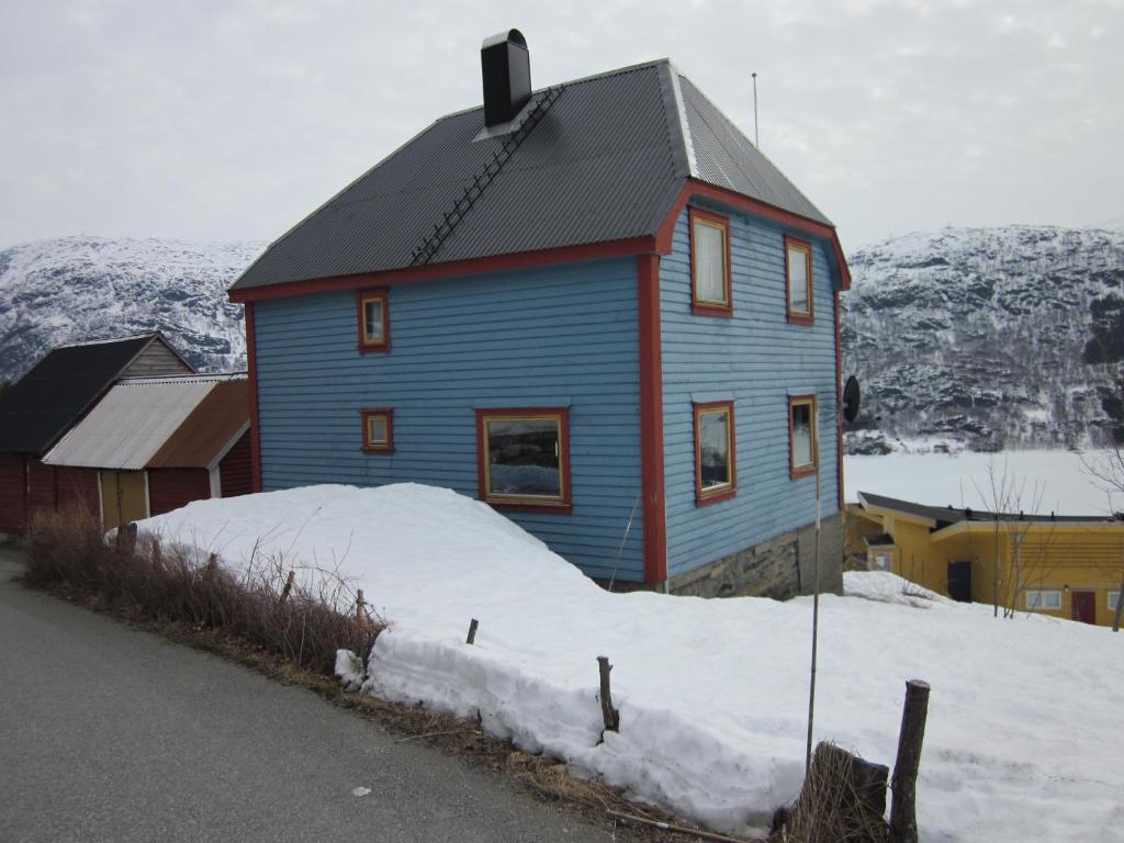 una casa azul sentada sobre una pila de nieve en The blue house, Røldal en Røldal